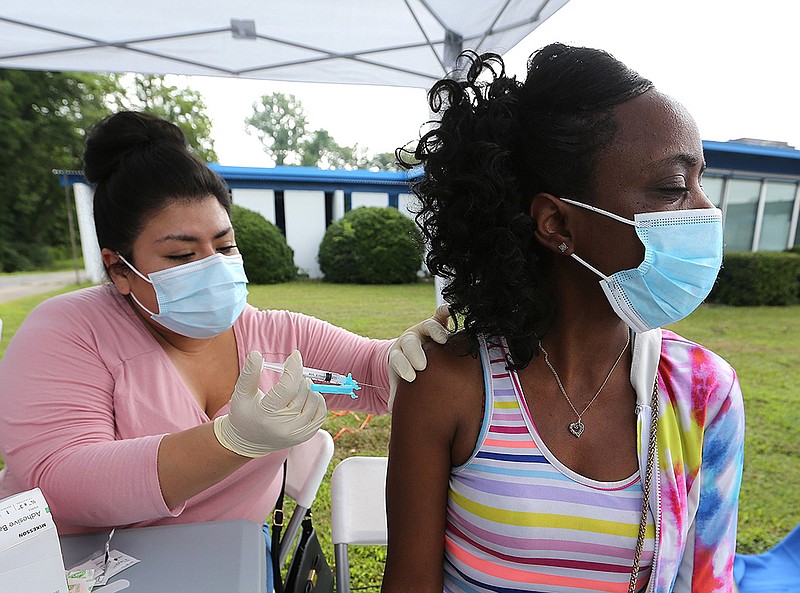 Jenifer Benitez, a nurse with the Arkansas Foundation for Medical Care, gives Rokenya Boykins a shot of the Johnson & Johnson vaccine Thursday during a job fair at the Watershed Family Resource Center in Little Rock. Arkansas Department of Health figures continue to show an uptick in the state’s vaccinations.
(Arkansas Democrat-Gazette/Thomas Metthe)