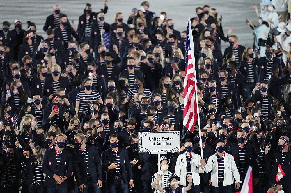 The United States flag-bearers, basketball player Sue Bird (left) and baseball player Eddy Alvarez, lead the American Olympic team during the parade of nations at the opening ceremony of the Tokyo Olympics on Friday.
(AP/Natacha Pisarenko)