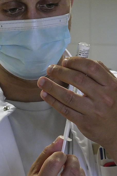 A medical worker prepares a dose of the Pfizer covid-19 vaccine Friday at a beach clinic in Carry le Rouet, southern France.
(AP/Nicolas Garriga)