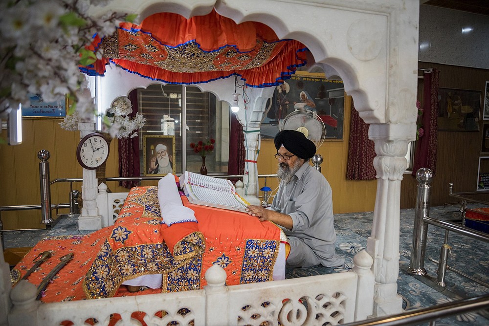 A man reads from a book of religious scripture inside the Srinagar, India-based Chatti Padshahi, a Sikh place of worship, called a gurudwara.
(The New York Times/Showkat Nanda)