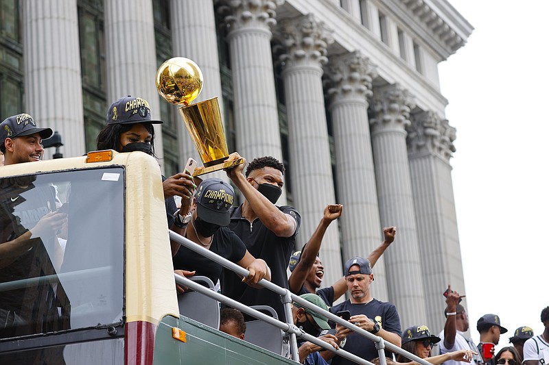 Milwaukee Bucks’ Giannis Antetokounmpo holds up the NBA Championship trophy during a parade and celebration for the basketball team Thursday, July 22, 2021, in Milwaukee. (AP Photo/Jeffrey Phelps)