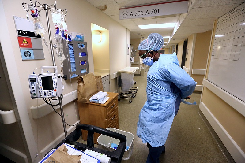 Nurse Brionna Rivers puts on PPE before going into a patient's room in one of the Covid wards at University of Arkansas for Medical Science on Thursday, July 22, 2021, in Little Rock. .More photos at www.arkansasonline.com/725covid/.(Arkansas Democrat-Gazette/Thomas Metthe)