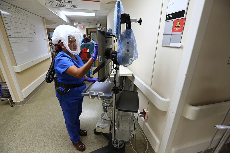 Nurse practitioner Naomi Crume, with the vascular access team, gets her equipment ready in the hallway of one of the Covid wards at University of Arkansas for Medical Science on Thursday, July 22, 2021, in Little Rock. .More photos at www.arkansasonline.com/725covid/.(Arkansas Democrat-Gazette/Thomas Metthe)