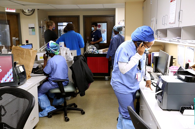 Nurse Takela Gardner (right) talks on the phone before making her rounds in one of the Covid wards at University of Arkansas for Medical Science on Thursday, July 22, 2021, in Little Rock. .(Arkansas Democrat-Gazette/Thomas Metthe)