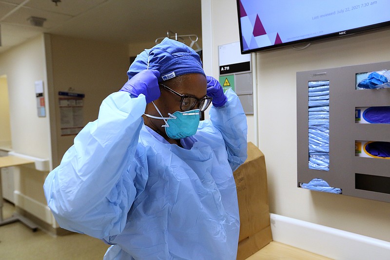Nurse Takela Gardner puts on PPE before entering a room in one of the Covid wards at University of Arkansas for Medical Science on Thursday, July 22, 2021, in Little Rock. .(Arkansas Democrat-Gazette/Thomas Metthe)