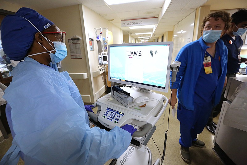 Nurse Takela Gardner heads to a Covid-19 patient's room in one of the Covid wards at University of Arkansas for Medical Science on Thursday, July 22, 2021, in Little Rock. .(Arkansas Democrat-Gazette/Thomas Metthe)