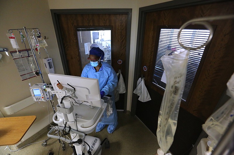 Nurse Takela Gardner looks over a patient's chart before entering a room in one of the Covid wards at University of Arkansas for Medical Science on Thursday, July 22, 2021, in Little Rock. .(Arkansas Democrat-Gazette/Thomas Metthe)