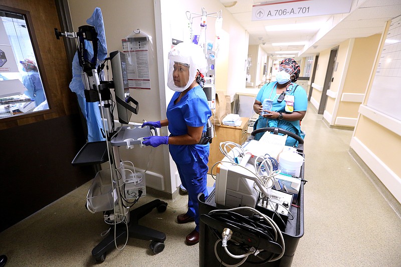 Nurse practitioner Naomi Crume, with the vascular access team, gets her equipment ready in the hallway of one of the Covid wards at University of Arkansas for Medical Science on Thursday, July 22, 2021, in Little Rock. .(Arkansas Democrat-Gazette/Thomas Metthe)