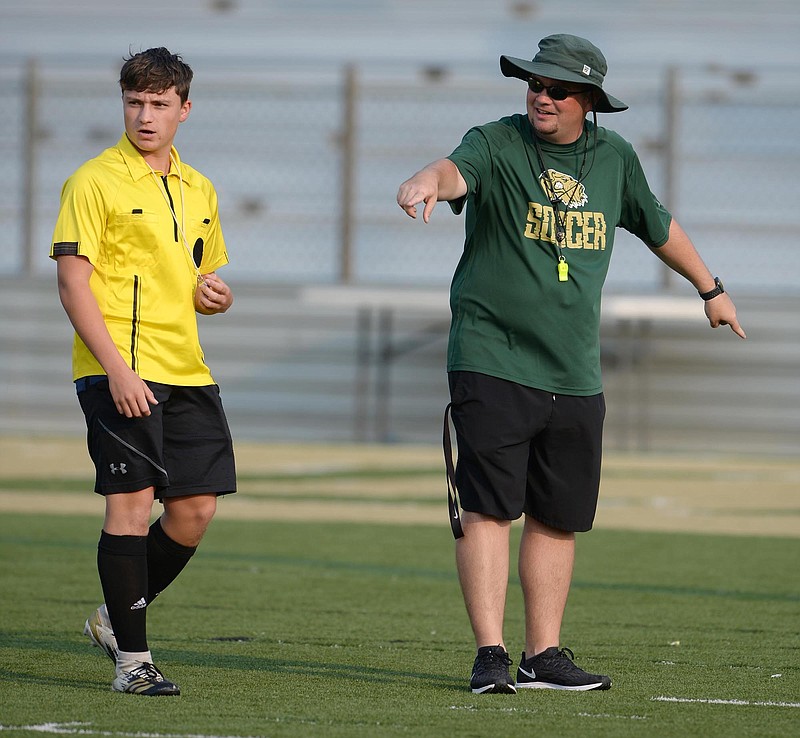 Alma coach Cory Sturdivant (right) explains the boundaries of the smaller, 7 on 7 soccer field Tuesday, July 20, 2021, for a game official during play at Airedale Stadium in Alma. Visit nwaonline.com/210726Daily/ for today's photo gallery..(NWA Democrat-Gazette/Andy Shupe)