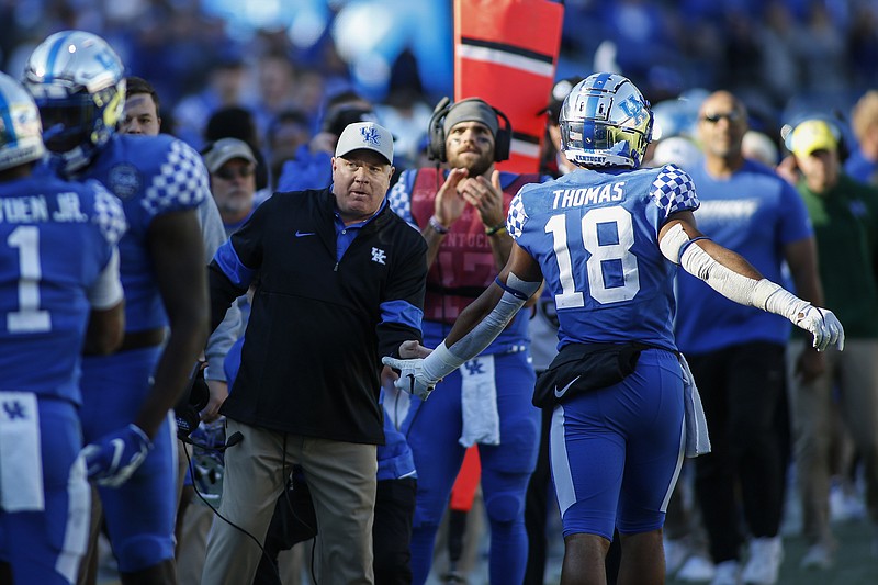 Kentucky head coach Mark Stoops greets Kentucky wide receiver Clevan Thomas Jr. as Kentucky scores against Virginia Tech in the second half of the Belk Bowl NCAA college football game in Charlotte, N.C., Tuesday, Dec. 31, 2019. Kentucky won 37-30. (AP Photo/Nell Redmond)