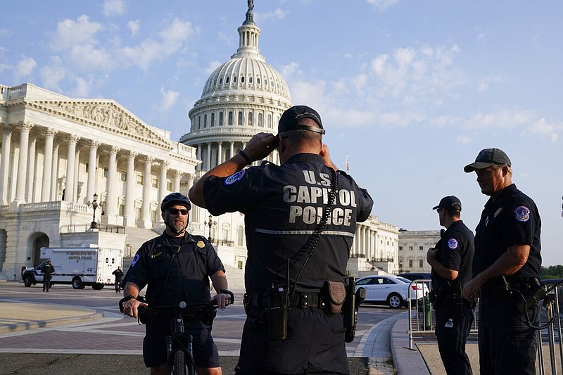 The U.S. Capitol is seen in Washington, early Tuesday, July 27, 2021, as U.S. Capitol Police watch the perimeter. (AP/J. Scott Applewhite)