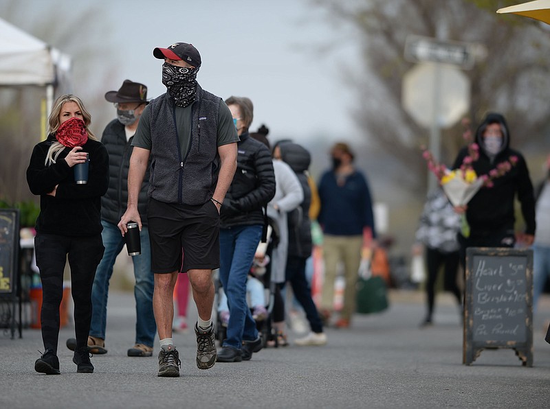 Patrons walk Saturday, April 3, 2021, while visiting the Fayetteville Farmers' Market on the Fayetteville downtown square. (NWA Democrat-Gazette/Andy Shupe)