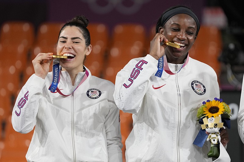 Kelsey Plum (left) celebrates with her gold medal after helping lead the United States to a victory over the Russian Olympic Committee in the final of women’s 3-on-3 basketball. Plum is a graduate assistant coach at the University of Arkansas. Her teammate Jacquelyn Young (right) is also shown with her gold medal.
(AP/Jeff Roberson)
