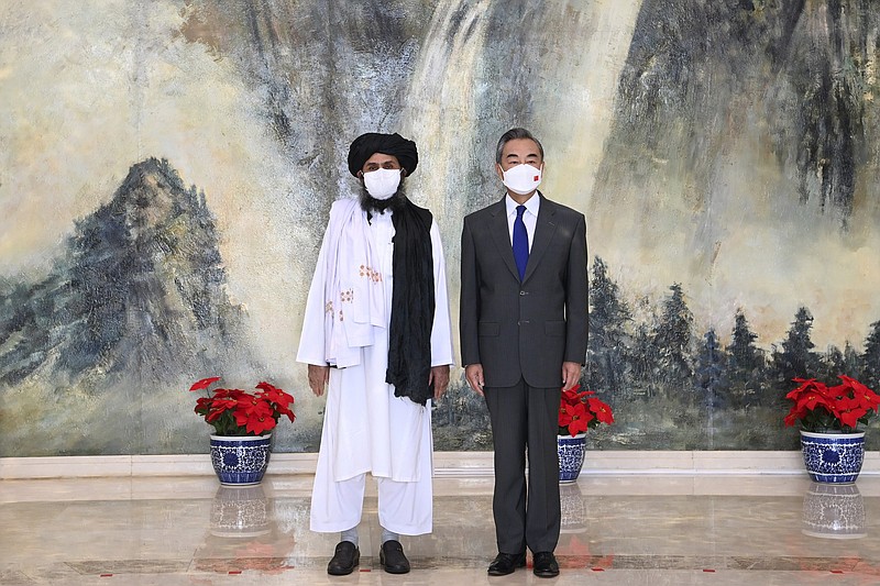 Taliban co-founder Mullah Abdul Ghani Baradar and Chinese Foreign Minister Wang Yi pose for a photo during their meeting Wednesday in Tianjin, China.
(AP/Xinhua/Li Ran)
