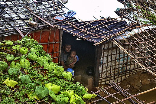 A Rohingya refugee sits with his child in their flooded shelter Wednesday at a Rohingya refugee camp in Kutupalong, Bangladesh. Days of heavy rains have in southern Bangladesh have left thousands of refugees homeless.
(AP/ Shafiqur Rahman)