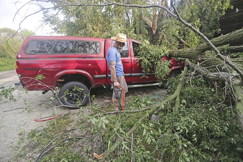 Adam Turley surveys the storm damage to his father’s truck Thursday in front of their home in Concord, Wis.
(AP/Milwaukee Journal-Sentinel/Mike De Sisti)