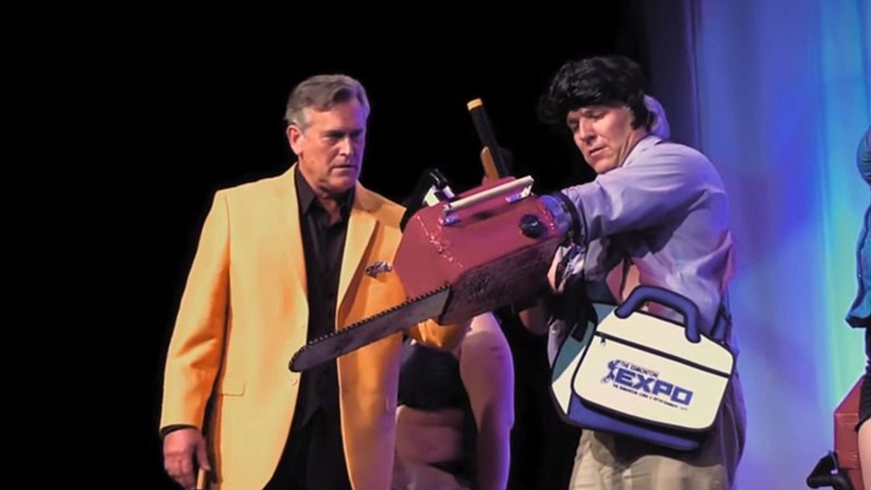 Bruce Campbell, who stars as Ash Williams in Sam Raimi’s “Evil Dead” and its sequels, inspects the costume of a cosplayer in a scene from the documentary “Hail to the Deadites.”