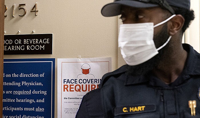 A U.S. Capitol Police officer stands on duty Thursday outside a House Committee on Oversight and Reform hearing. Some GOP lawmakers are hinting at a fight over stringent federal mask and vaccination rules.
(AP/Jacquelyn Martin)