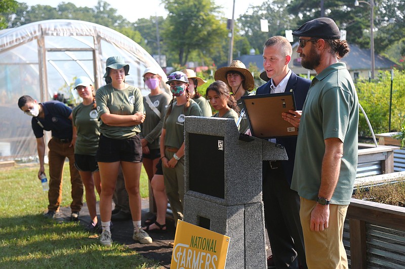 Arkansas Agriculture Secretary Wes Ward presents the governor’s proclamation, declaring Aug. 1-7 Arkansas Farmers’ Market Week, at the University of Arkansas at Little Rock Community Garden. 
(Special to The Commercial/University of Arkansas System Division of Agriculture/l/Ryan McGeeney)