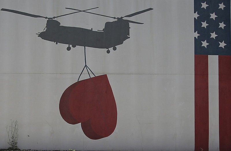 A painting projects a hopeful image on the wall Friday at the U.S. Embassy in Kabul, Afghanistan. An initial group of about 2,500 Afghans who provided aid to U.S. forces is being evacuated under threat of reprisals by Taliban militants.
(AP/Mariam Zuhaib)