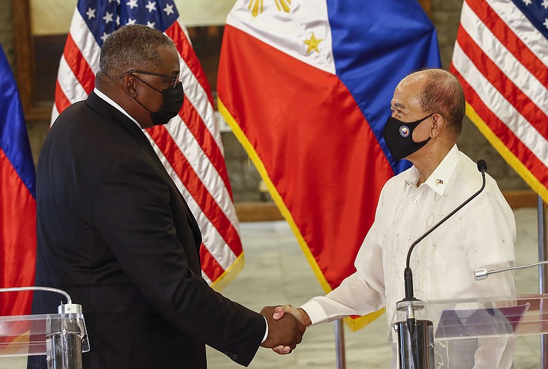 United States Defense Secretary Lloyd Austin (left) and Philippines Defense Secretary Delfin Lorenzana shake hands Friday after a bilateral meeting at Camp Aguinaldo military camp in Quezon City, Metro Manila, Philippines.
(AP/Pool/Rolex dela Pena)