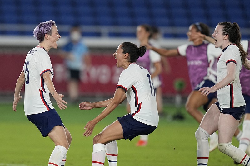 United States' Megan Rapinoe, left, celebrates with teammates after scoring the winning goal and defeating the Netherlands in a penalty shootout during a women's quarterfinal soccer match at the 2020 Summer Olympics, Friday, July 30, 2021, in Yokohama, Japan. (The Associated Press)