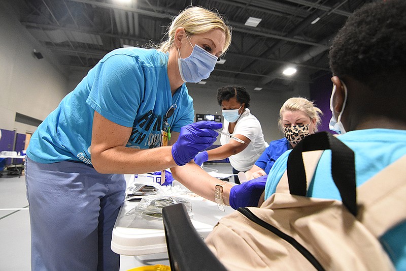 Candace Priddy, a physician assistant for UAMS, administers a dose of the Pfizer coronavirus vaccine Saturday, July 31, 2021, during a community wide, back-to-school event at Southwest High School in Little Rock. (Arkansas Democrat-Gazette/Staci Vandagriff)