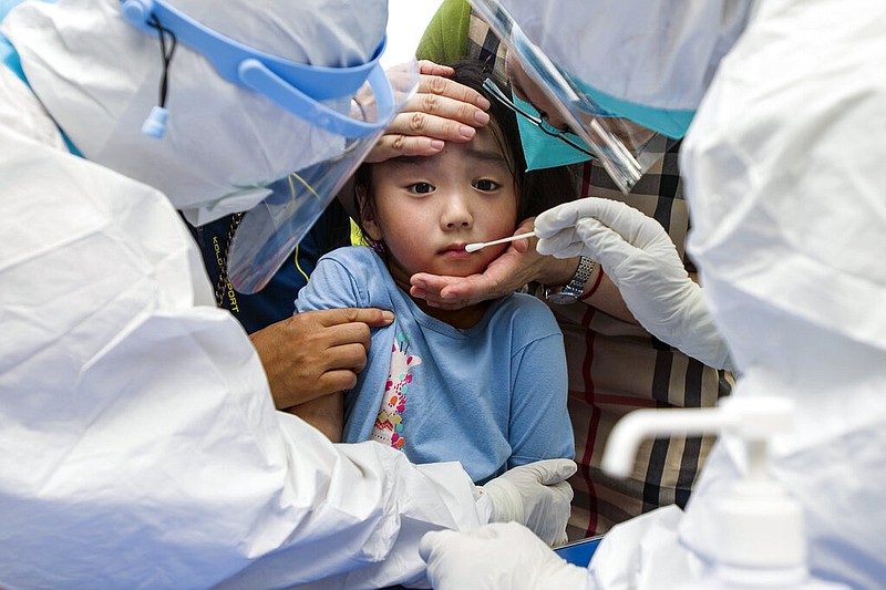 A child reacts to a throat swab during mass testing for COVID-19 in Wuhan in central China's Hubei province Tuesday, Aug. 3, 2021. (Chinatopix via AP)