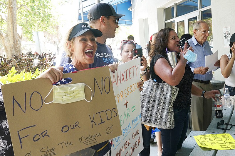 Joann Marcus (left) of Fort Lauderdale, Fla., cheers as she listens to the Broward School Board's emergency meeting in Fort Lauderdale in this July 28, 2021, file photo. Marcus was among those speaking against mask mandates in schools, saying parents' personal rights were being eroded and their children were suffering socially. (AP/Marta Lavandier)