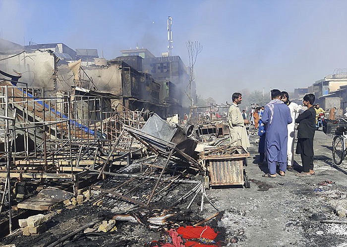 Afghans inspect damaged shops after fighting between Taliban and Afghan security forces in Kunduz city, northern Afghanistan, Sunday, Aug. 8, 2021. Taliban fighters Sunday took control of much of the capital of  Kunduz province, including the governor's office and police headquarters, a provincial council member said. (AP Photo/Abdullah Sahil)