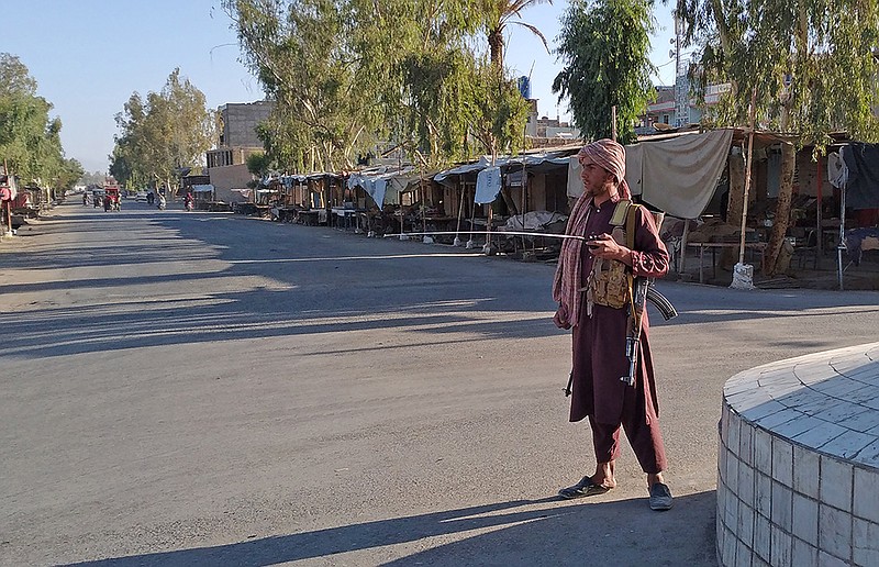 A Taliban fighter stands guard Wednesday inside the city of Farah in western Afghanistan a day after government forces were overrun. One soldier’s body was dragged through the street as Taliban fighters shouted, “God is great!”
(AP/Mohammad Asif Khan)