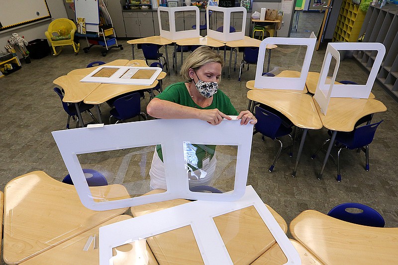 First-grade teacher Cindy Lupton puts up social distancing barriers on student desks while preparing her classroom on Wednesday at Lakewood Elementary School in North Little Rock.
(Arkansas Democrat-Gazette/Thomas Metthe)