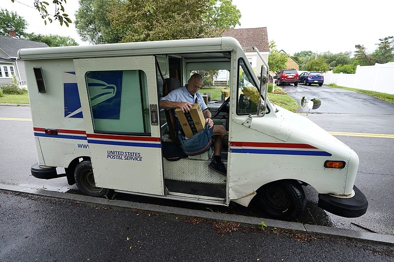 U.S. Postal Service carrier John Graham packs his mail bag after parking a 28-year-old delivery truck in Portland, Maine. The primary fleet of postal vehicles delivered starting in 1987 is set to be replaced under a new contract, but the winning bid is being challenged.
(AP/Robert F. Bukaty)