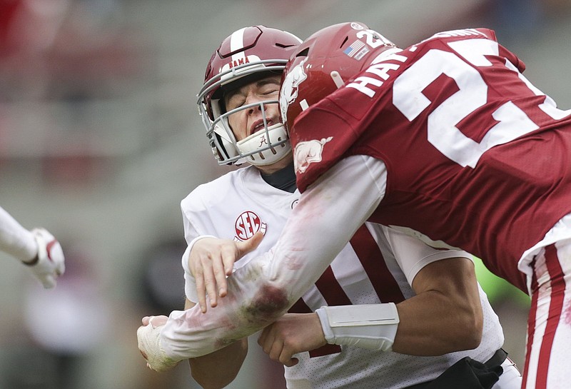 Senior Hayden Henry, shown making a tackle on Alabama quarterback Mac Jones last season, has a style of play that linebackers coach Michael Scherer said is similar to something seen in the movies. “If you watch him at practice, he’s not far off from Bobby Boucher,” said Scherer, referencing Adam Sandler’s character in “The Waterboy.” “He’s just a little smarter.”
(NWA Democrat-Gazette/Charlie Kaijo)