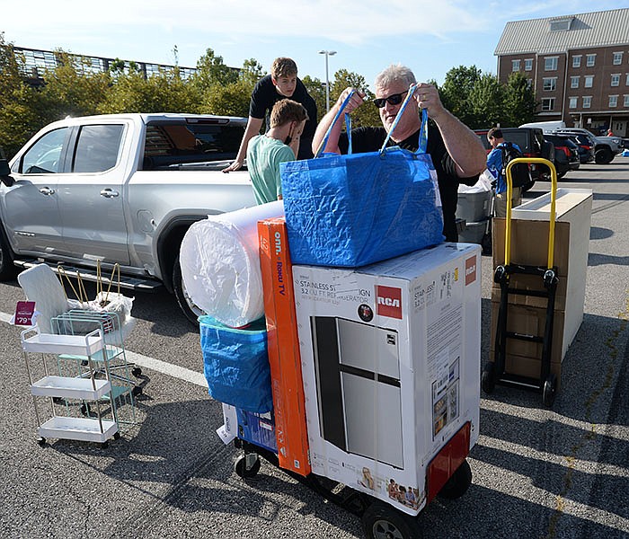 David Swindle of Little Rock hefts bags onto a dolly Thursday as he helps move his daughter into a dormitory on the University of Arkansas, Fayetteville campus.
(NWA Democrat-Gazette/Andy Shupe)