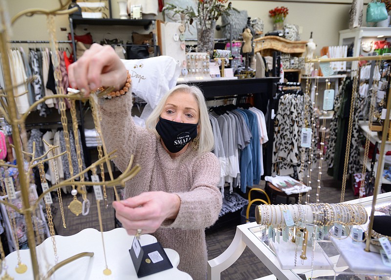 FILE -- Sherry Puttkammer, owner of The Dotted Pig in downtown Rogers, places new necklaces Thursday, Dec. 31, 2020, on a rack as she begins to fill her store with new merchandise as the shopping seasons change. 
(NWA Democrat-Gazette/Andy Shupe)