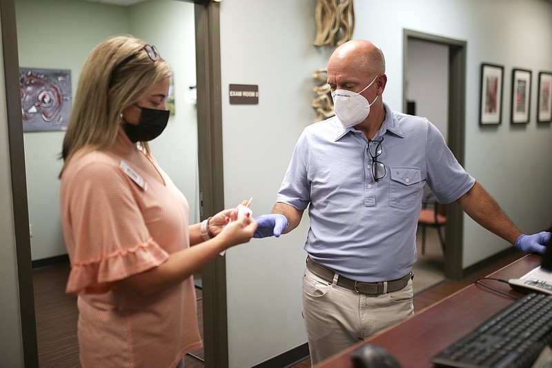 Office manager Tamie Cart and Dr. Jonathan Parker work Thursday at the Mana Health Clinic in Springdale. Parker is encouraging members of the Phi Delta Theta fraternity at the University of Arkansas to get vaccinated.
(NWA Democrat-Gazette/Charlie Kaijo)