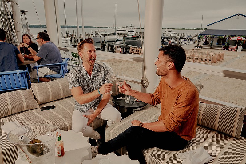 Benjamin Dizon (left) and Bernard Teller split a bottle of white wine at Si Si in Springs, East Hampton, N.Y., last month. The artsy and quieter hamlet of the Hamptons has seen an influx of Manhattanites, buzzy restaurants and even celebrities.
(The New York Times/Victor Llorente)