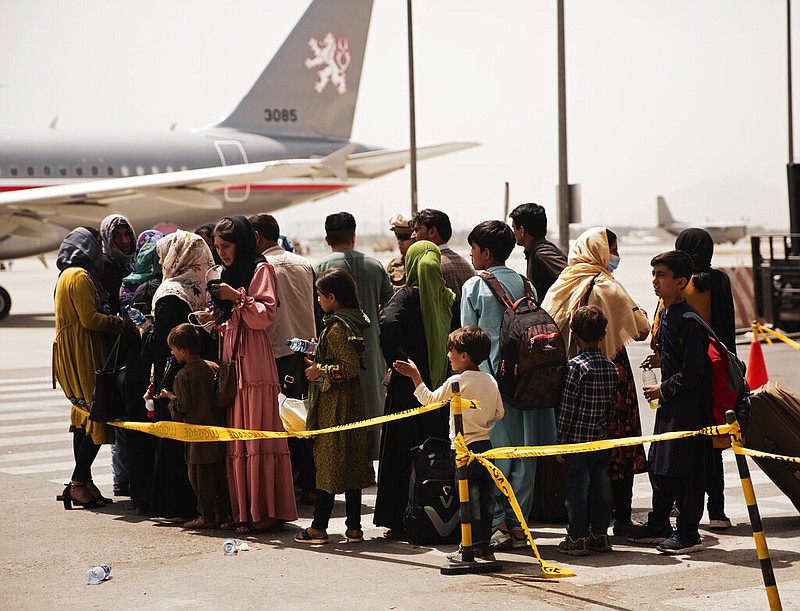 In this photo provided by the U.S. Marine Corps, civilians prepare to board a plane during an evacuation at Hamid Karzai International Airport in Kabul, Afghanistan, on Wednesday, Aug. 18, 2021. (Staff Sgt. Victor Mancilla/U.S. Marine Corps via AP)
