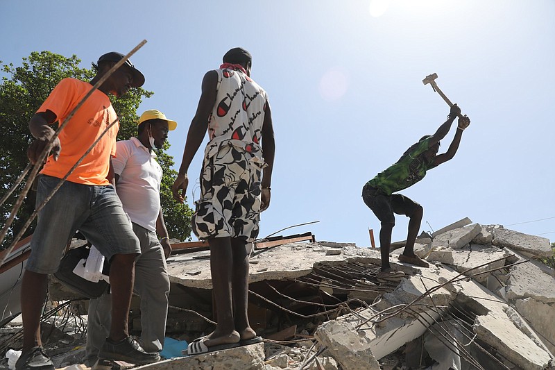 Joseph Jean Fetal (right) uses a sledgehammer to break concrete slabs in an attempt to retrieve important documents from an earthquake damaged church in Les Cayes, Haiti on Sunday. Haitians struggled with a lack of basic supplies, including food and medical care, in the aftermath of the magnitude 7.2 earthquake.
(The New York Times/Valerie Baeriswyl)