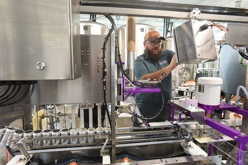 Greg Martin starts the beer canning machinery on Wednesday at Bentonville Brewing Co. in Rogers. It’s the craft beer-maker’s first canning line.
(NWA Democrat-Gazette/Flip Putthoff)