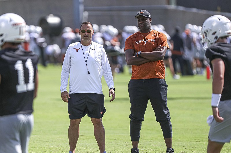 Texas coach Steve Sarkisian, left, is joined by former Texas quarterback Vince Young, right, during the NCAA college football team's practice Saturday, Aug. 7, 2021, in Austin, Texas. (Aaron E. Martinez/Austin American-Statesman via AP)