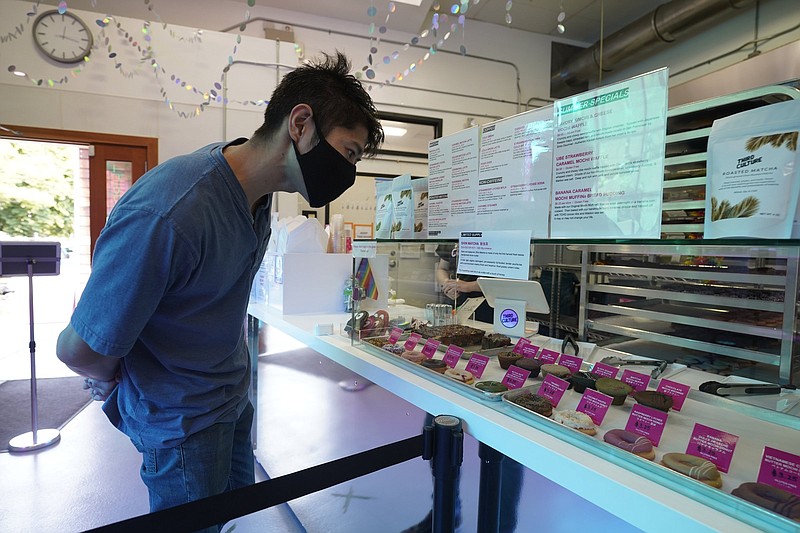 A display case filled with mochi doughnuts and muffins draws a customer’s attention last week at the Third Culture Bakery in Berkeley, Calif.
(AP/Eric Risberg)