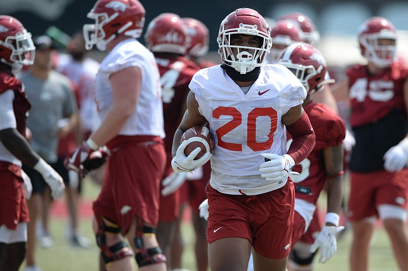 Sophomore Dominique Johnson (shown carrying ball) was the recipient of some good-natured humor by Arkansas Coach Sam Pittman on Wednesday night. Johnson was moved from running back to tight end earlier in camp before returning to the backfield. “He was like twice as good,” Pittman said. “But really, he got a lot better. I don’t know why, but he did. He started running the ball better.”
(NWA Democrat-Gazette/Andy Shupe)