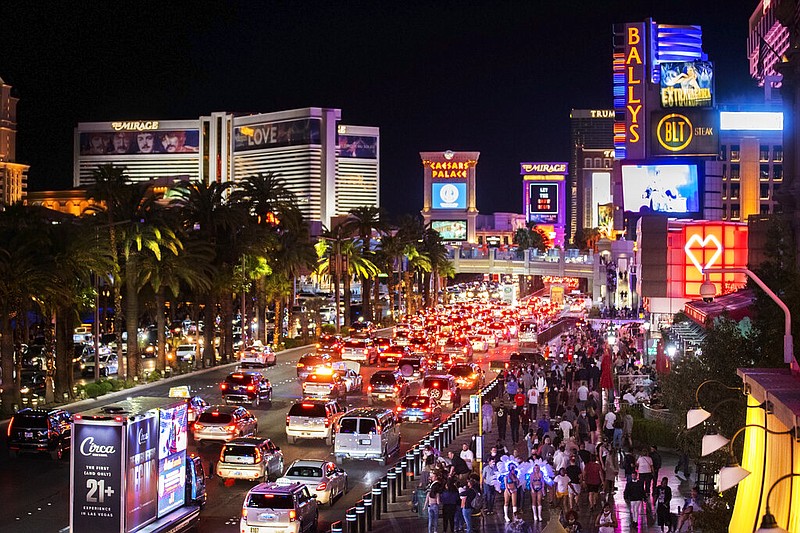 Vehicles and crowds move along the strip in Las Vegas in this March 19, 2021, file photo. (Benjamin Hager/Las Vegas Review-Journal via AP)