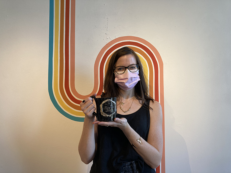 Bang-Up Betty owner Stacey Bowers holds up a mug bearing the company's name in her Argenta shop on Tuesday. (Arkansas Democrat-Gazette/Haley Fuller)