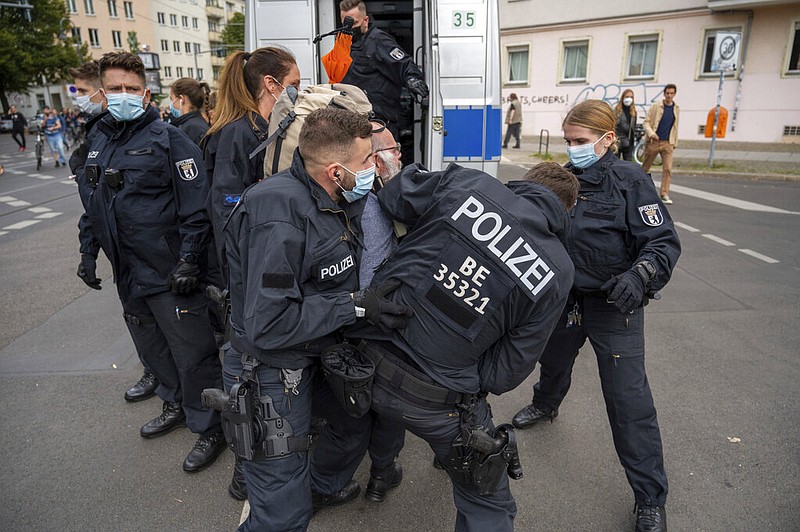 Police in Berlin restrain a demonstrator Saturday, Aug. 28, 2021, during a protest against coronavirus restrictions. (Christophe Gateau/dpa via AP)