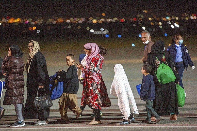 Families evacuated from Kabul, Afghanistan, walk at the international airport in Pristina, the capital of Kosovo, on Sunday, Aug. 29, 2021. The Afghans came from the Ramstein military base in Germany, and they will be housed near the U.S. military Camp Bondsteel, 25 miles south of the capital Pristina. (AP/Visar Kryeziu)