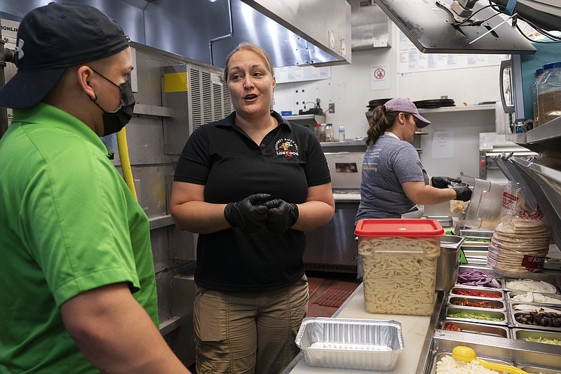 Sarah White, area manager of Lost Dog Cafe, trains manager Alex Aleman in a new pasta preparation technique as they work last week at the cafe in Fairfax, Va.
(AP/Jacquelyn Martin)