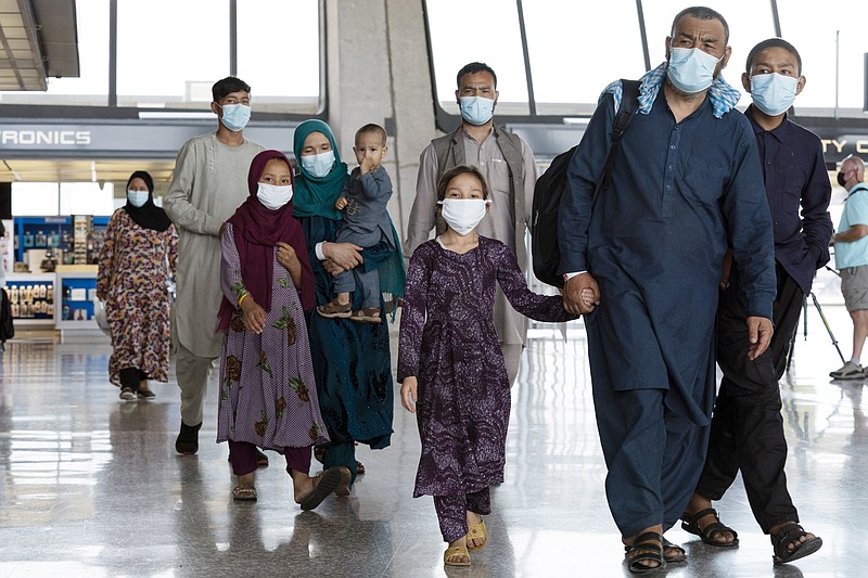 FILE -- Families evacuated from Kabul, Afghanistan, walk through the terminal before boarding a bus after they arrived at Washington Dulles International Airport, in Chantilly, Va., on Monday, Aug. 23, 2021. (AP Photo/Jose Luis Magana)